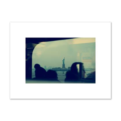 Fine art photograph of passengers silhouetted on a crowded ferry with the Statue of Liberty in the background, archival pigment print, small size, unframed.