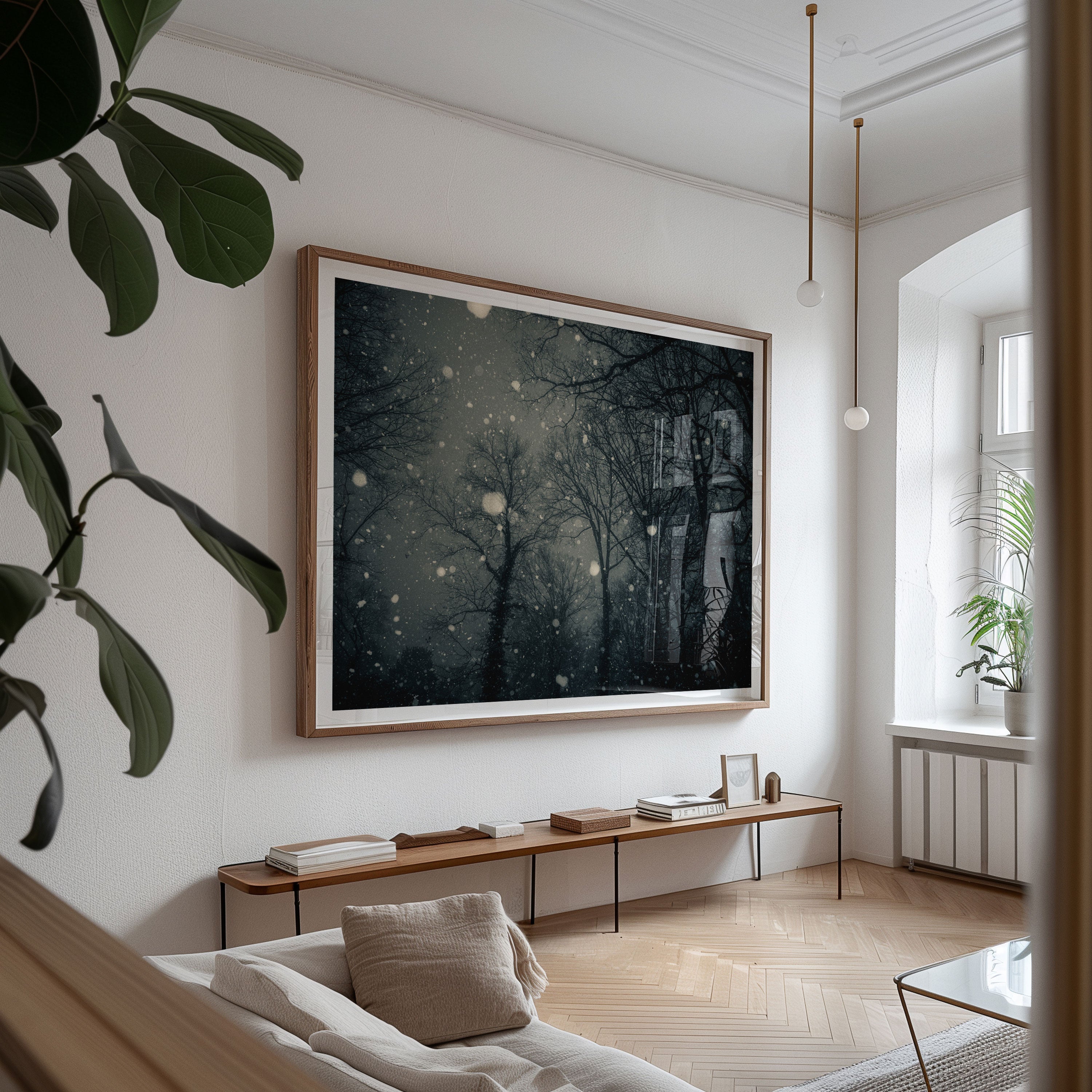 A framed fine art photography of snowfall in a forest hangs in a well designed contemporary living room.