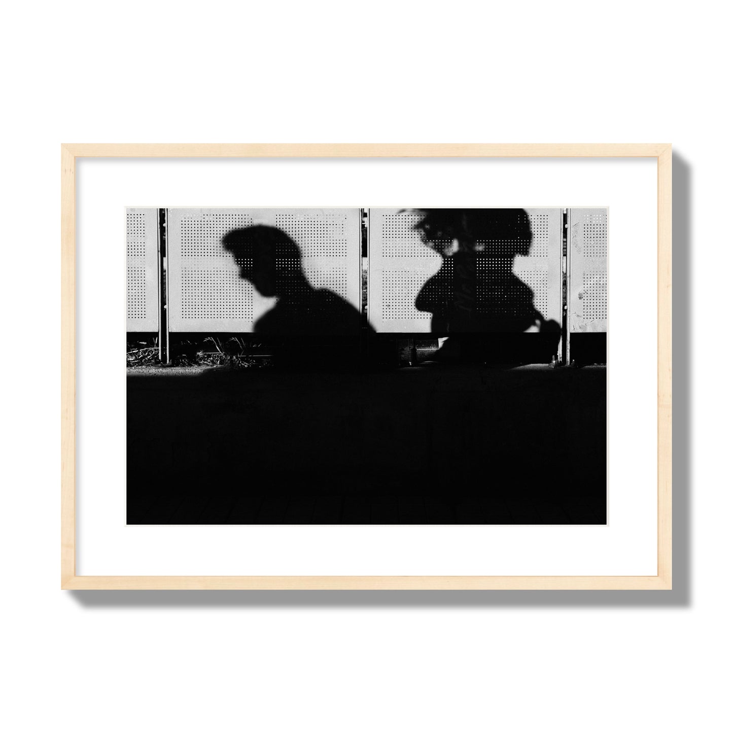 Fine art black and white street photography capturing the silhouettes of two individuals against a wall in Athens Greece, archival pigment print, large size, natural wood frame