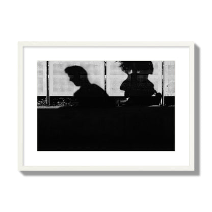 Fine art black and white street photography capturing the silhouettes of two individuals against a wall in Athens Greece, archival pigment print, large size, frame frame