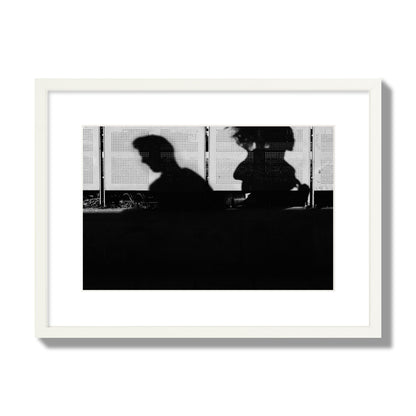 Fine art black and white street photography capturing the silhouettes of two individuals against a wall in Athens Greece, archival pigment print, medium size, white frame