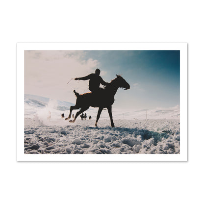 Fine art photography of a silhouetted man riding a galloping horse in a snowy field with a mountain backdrop, archival pigment print, gallery size, print.