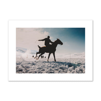 Fine art photography of a silhouetted man riding a galloping horse in a snowy field with a mountain backdrop, archival pigment print, large size, print.