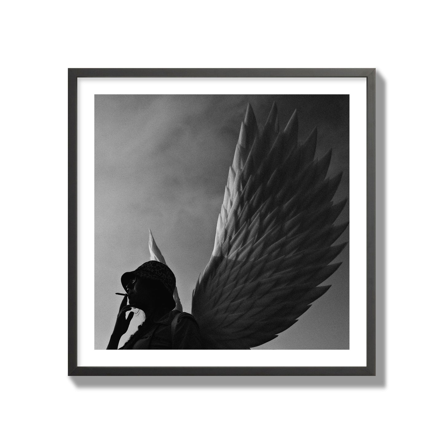 Fine art photography of a woman smoking in front of a winged statue, archival pigment print, collector size, black frame.