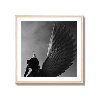 Fine art photography of a woman smoking in front of a winged statue, archival pigment print, collector size, natural wood frame.