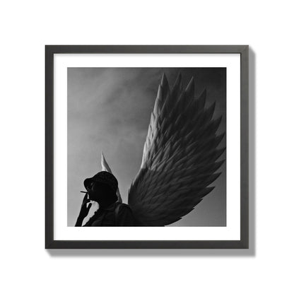 Fine art photography of a woman smoking in front of a winged statue, archival pigment print, giant size, black frame.