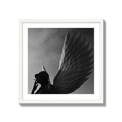 Fine art photography of a woman smoking in front of a winged statue, archival pigment print, giant size, white frame.
