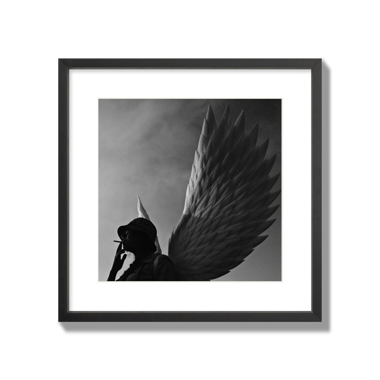 Fine art photography of a woman smoking in front of a winged statue, archival pigment print, large size, black frame.
