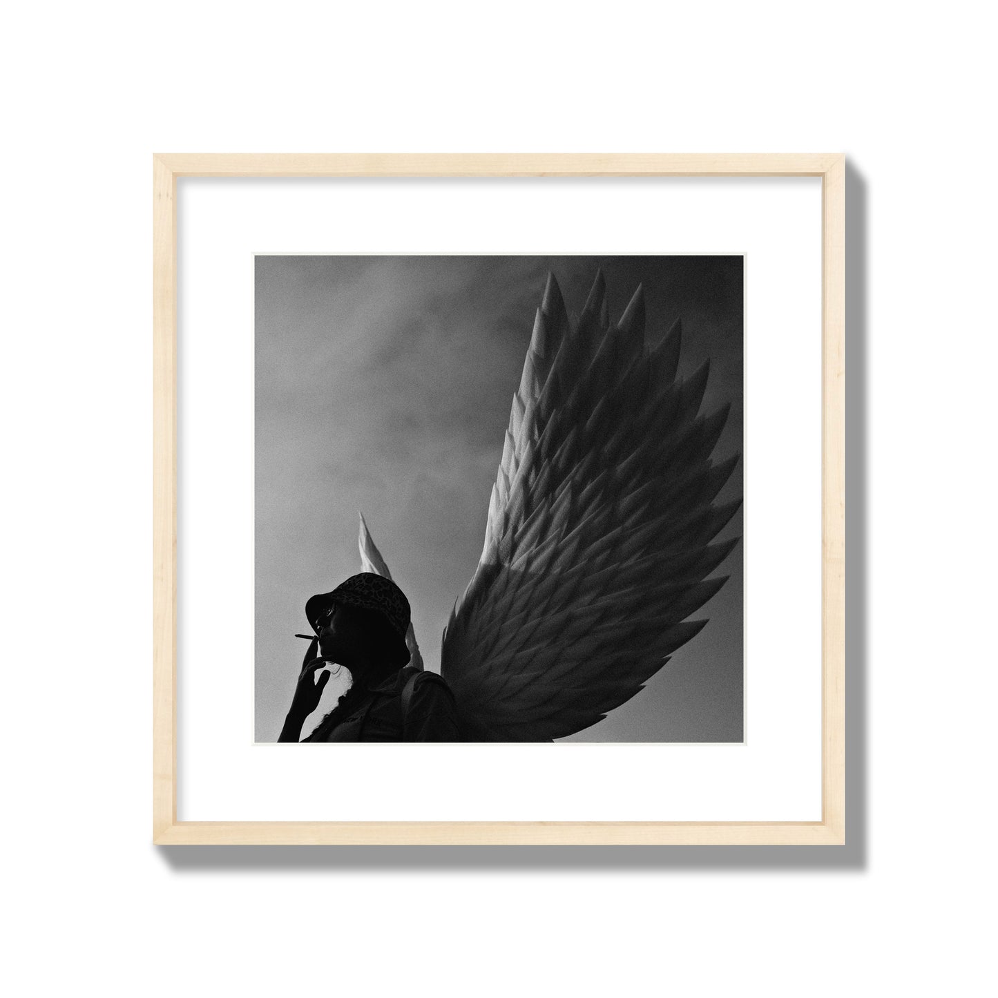 Fine art photography of a woman smoking in front of a winged statue, archival pigment print, large size, natural wood frame.