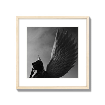 Fine art photography of a woman smoking in front of a winged statue, archival pigment print, large size, natural wood frame.