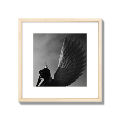 Fine art photography of a woman smoking in front of a winged statue, archival pigment print, medium size, natural wood frame.