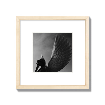 Fine art photography of a woman smoking in front of a winged statue, archival pigment print, small size, natural wood frame.