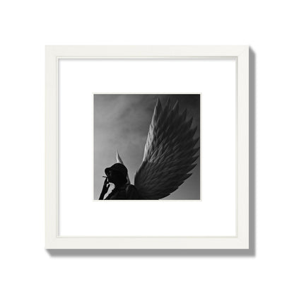 Fine art photography of a woman smoking in front of a winged statue, archival pigment print, small size, white frame.